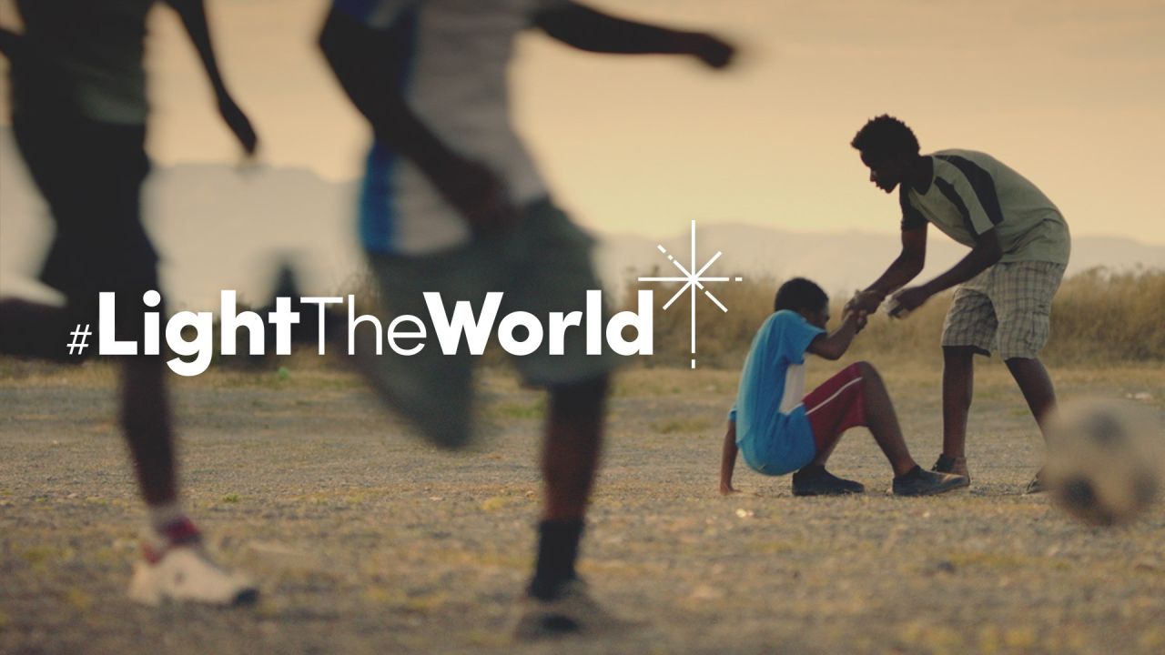 Chlapec pomáha inému chlapcovi vstať po tom, čo spadol pri hraní futbalu – z videa Rozsvieťte svet